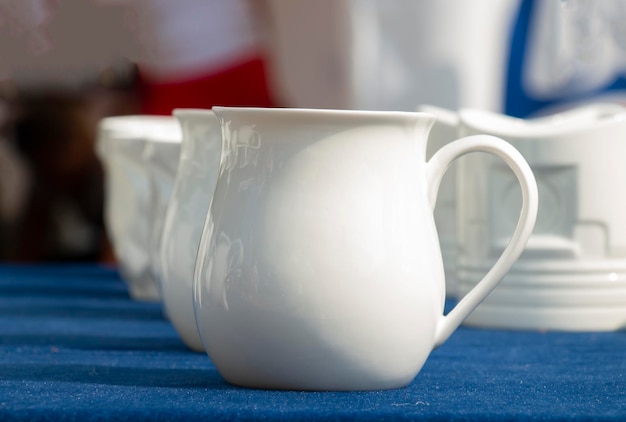 Hermosas tazas blancas sobre una mesa azul