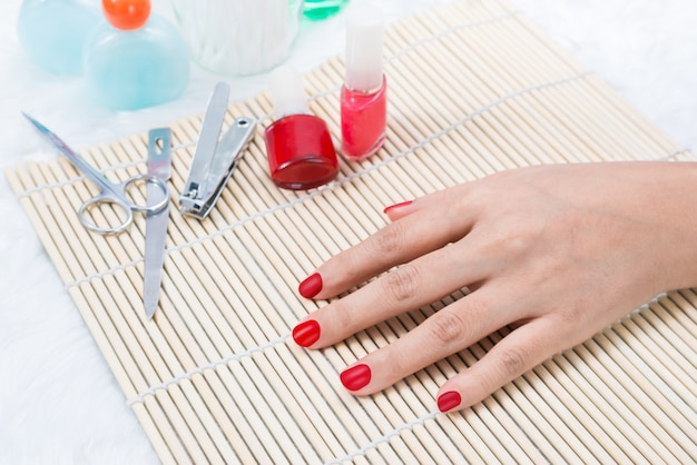 Hermosas uñas de mujer cuidadas con esmalte de uñas rojo.