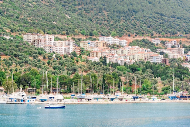 Hermosas vistas de la ciudad turística del puerto deportivo en las montañas y el yate parado en la orilla