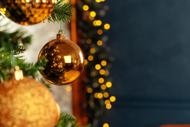 Hermoso adorno dorado colgando de un árbol de Navidad