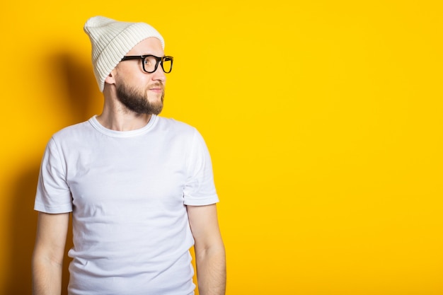 Hermoso amable joven con barba con sombrero y gafas de sol