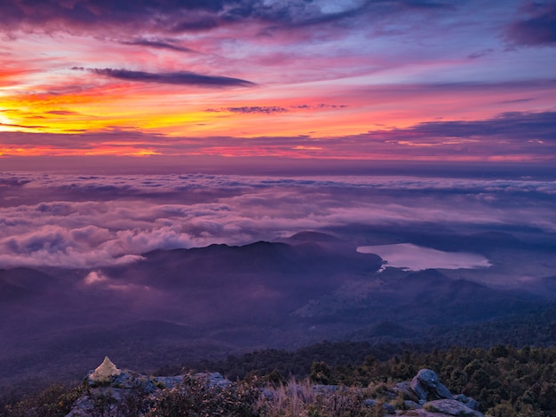 Hermoso amanecer en el cielo con el mar de la niebla de la niebla y la pequeña pagoda dorada en la mañana en la montaña Khao Luang