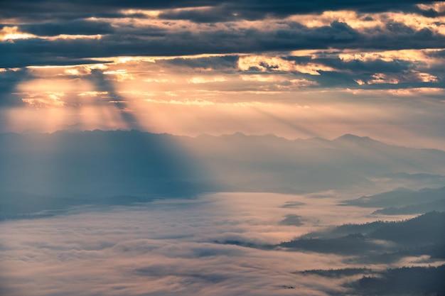 Hermoso amanecer dramático que brilla en la montaña con niebla en el valle en el parque nacional Doi Dam Wiang Haeng Chiang Mai Tailandia