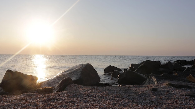 Un hermoso amanecer sobre los fondos de piedra en primer plano del mar