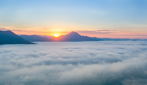 Hermoso amanecer sobre la montaña con niebla por la mañana