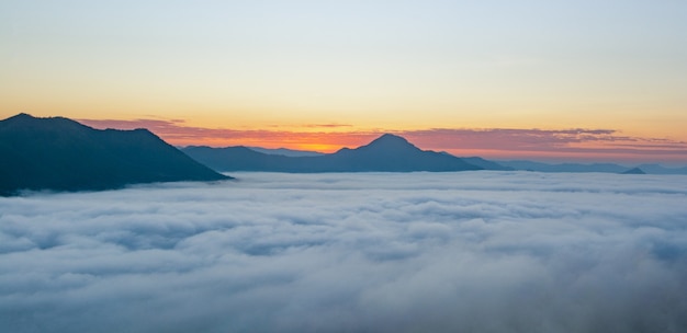 Hermoso amanecer sobre la montaña con niebla por la mañana