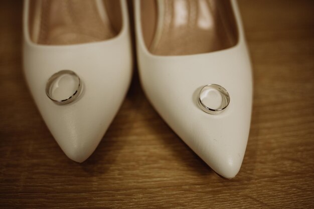 Hermoso anillo de bodas en los zapatos blancos de la novia.