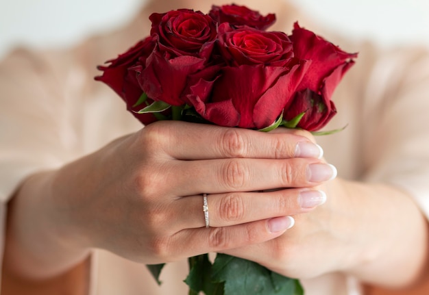 Foto un hermoso anillo elegante con diamantes en el dedo y hermosas rosas.