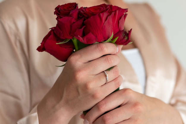 Un hermoso anillo elegante con diamantes en el dedo y hermosas rosas.