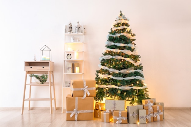 Hermoso árbol de Navidad con cajas de regalo en el interior del salón