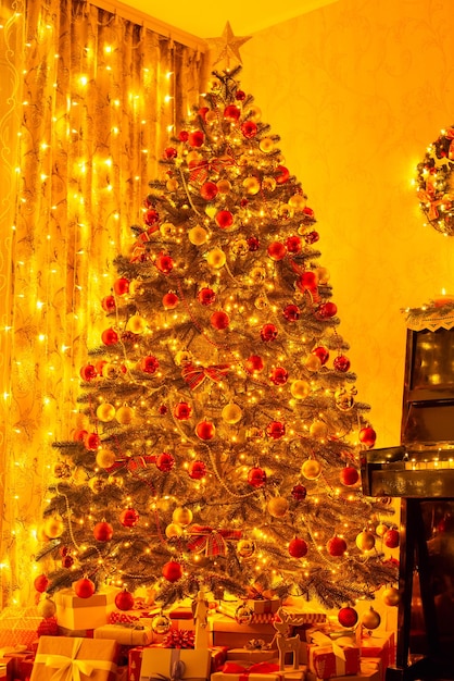 Hermoso árbol de Navidad decorado con luces brillantes en la sala de estar