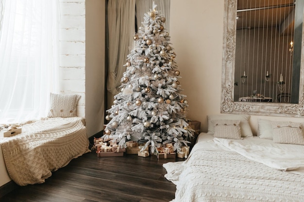 Un hermoso árbol de Navidad en una sala de estar decorada con una cama Interior festivoNavidad