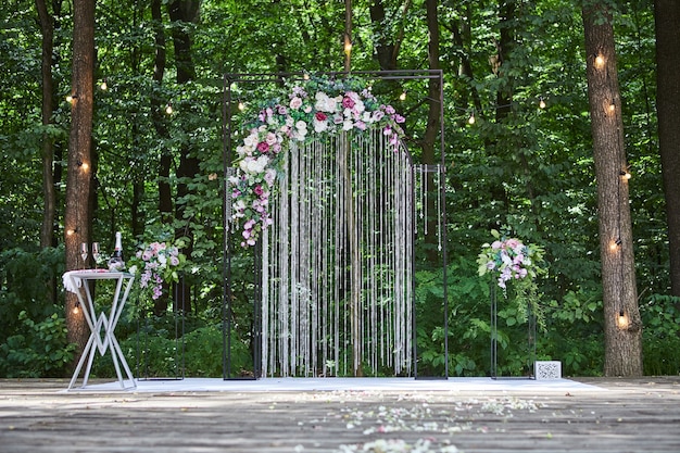 Hermoso arco de boda para ceremonia en estilo rústico ubicado en bosque