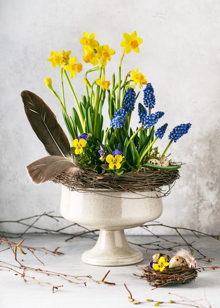 Hermoso arreglo florístico de primavera con narciso jacinto de uva azul y flores de viola