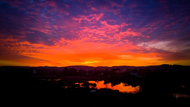 Foto hermoso atardecer ardiente sobre el bosque y el lago