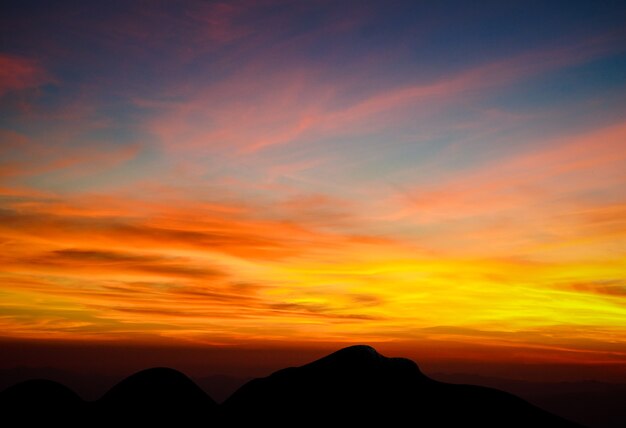 Hermoso atardecer y cielo, luz del amanecer y fondo de vista a la montaña shiluette.