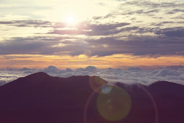 Hermoso atardecer en la colina por encima de las nubes