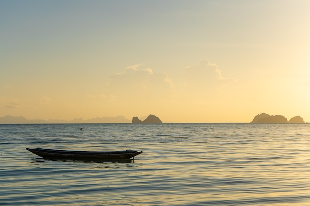 Hermoso atardecer en la costa de una isla tropical en Tailandia, la silueta de un barco en el océano