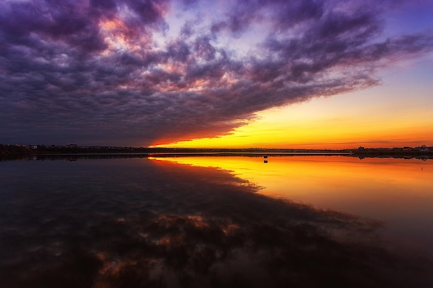 Hermoso atardecer en el lago con nubes y reflejos en el agua