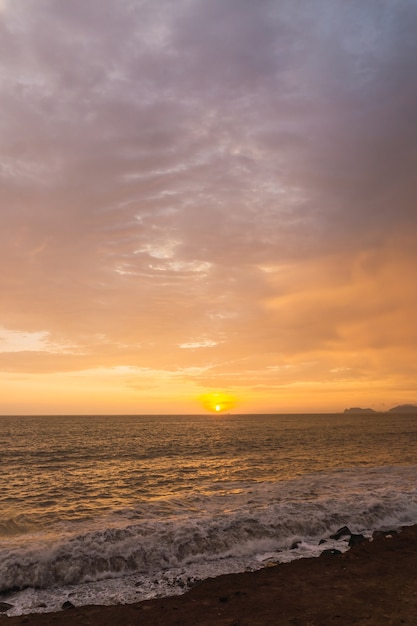 Hermoso atardecer en Lima, Perú, cielo brillante y playa subexpuesta