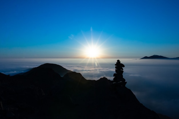 hermoso atardecer en las montañas silueta de columna de piedra