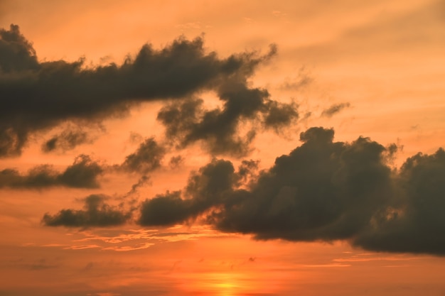 Hermoso atardecer naranja dramático con nubes mullidas sobre el cielo despejado, vista de ángulo bajo