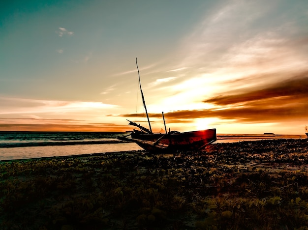 Hermoso atardecer en la playa con barco