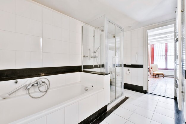 Foto hermoso baño con una gran bañera y paredes blancas.