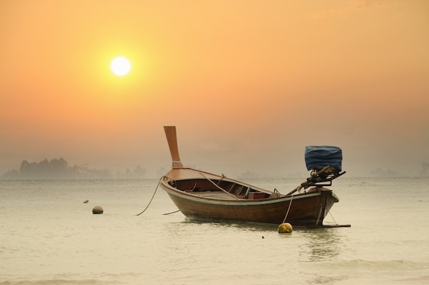 Hermoso barco en un lago en la hermosa puesta de sol de luz roja