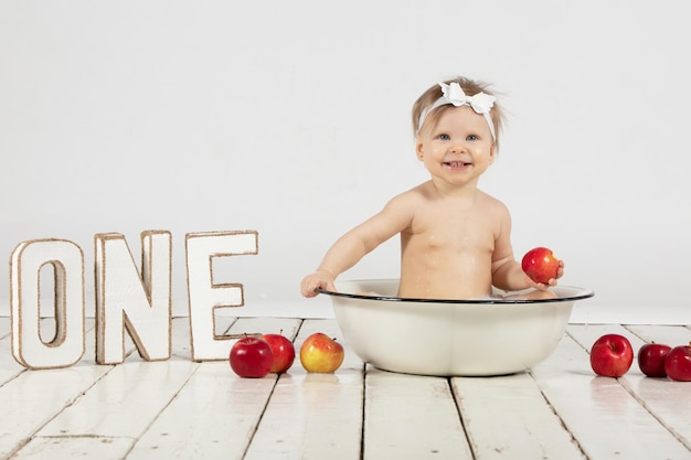 Hermoso bebé se baña en un lavabo Bebé de un año en su primer cumpleaños