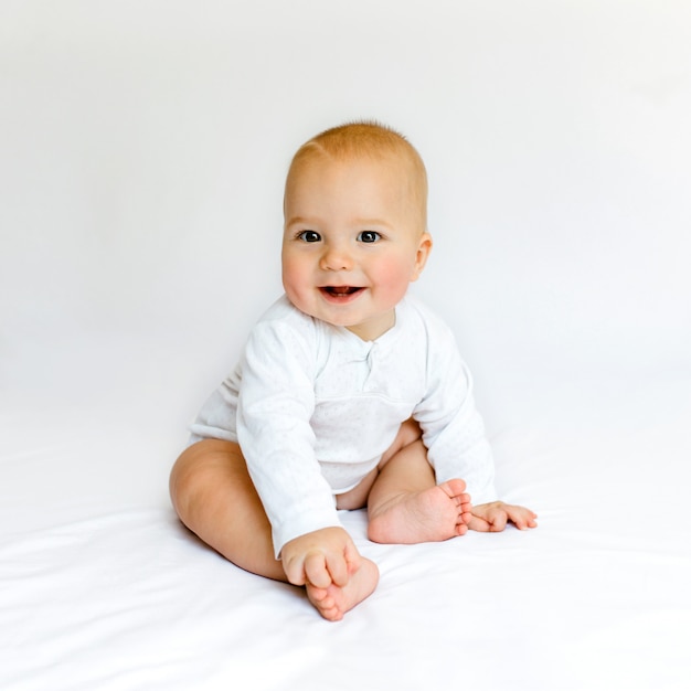 Foto hermoso bebé en la cama blanca.