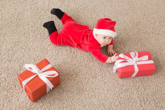 Hermoso bebé celebra la Navidad. Vacaciones de año nuevo. Bebé en traje de Navidad y en