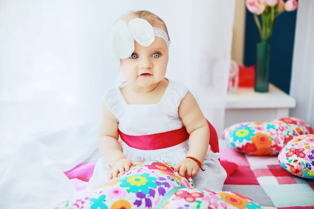 Hermoso bebé con un elegante vestido blanco. infancia.