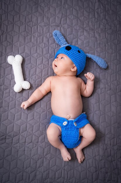 Hermoso bebé recién nacido con un pequeño juguete tendido en la cama Retrato de bebé