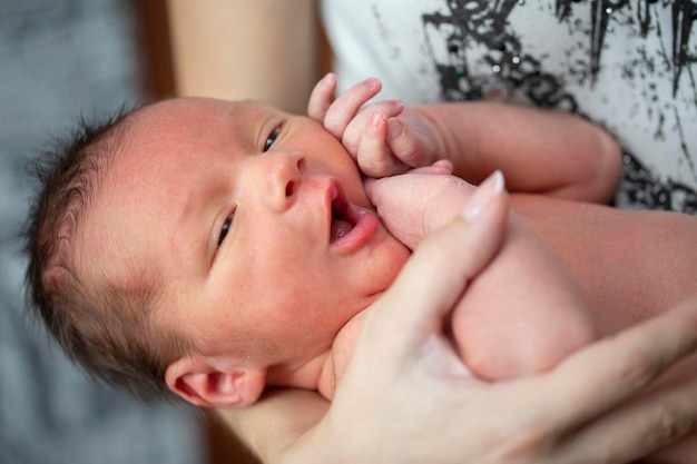 Foto hermoso bebé recién nacido en sus brazosel niño tiene siete días