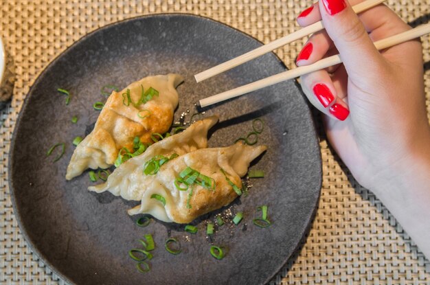 Hermoso bocadillo de gyoza o albóndigas con salsa de soja enfoque selectivo