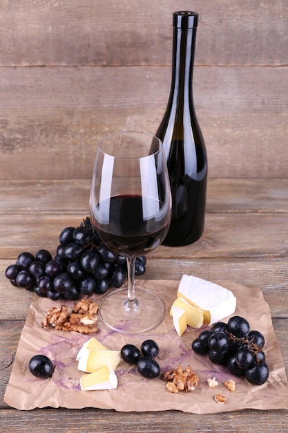 Hermoso bodegón con queso de vino y uva madura sobre fondo de madera