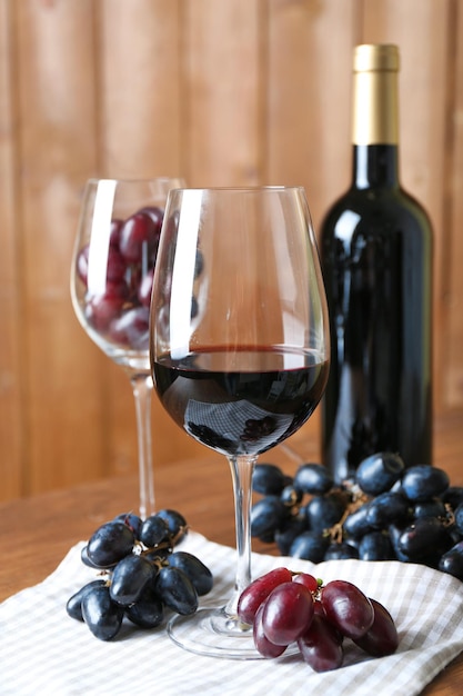 Hermoso bodegón con vino y uva en la mesa de madera