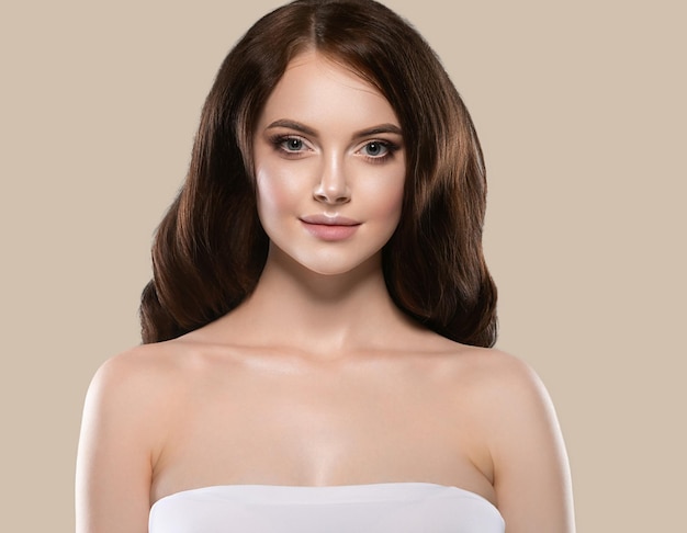 Hermoso cabello piel mujer retrato natural maquillaje pelo largo y rizado. Fondo de color marrón