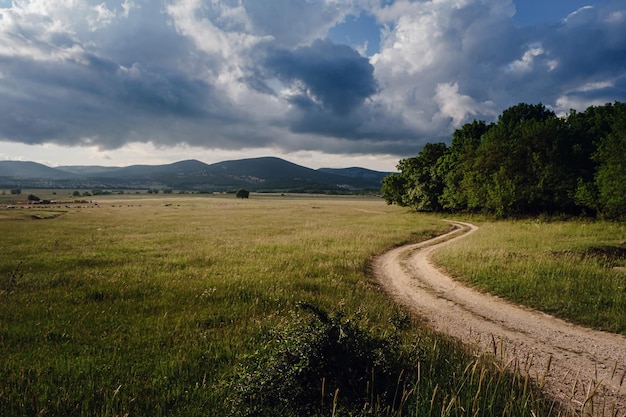 Hermoso camino rural antes de una tormenta al atardecer