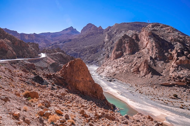 Hermoso camino sinuoso a través de montañas con río en verano