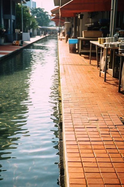 Foto hermoso canal a lo largo de la calle el agua fluye en la calle con azulejos naranja orientación vertical