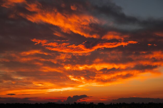 Hermoso cielo al atardecer ardiente, naranja y rojo. Escena mágica de la noche. Composición de la naturaleza