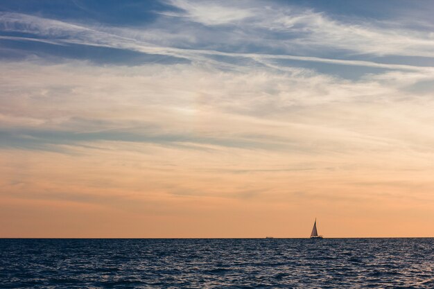 Un hermoso cielo con un bote en el mar con nubes sobre