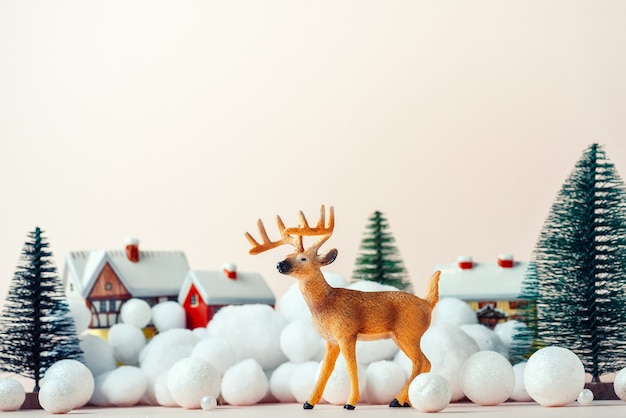 Hermoso ciervo en Nochebuena en el fondo de casas rurales, maqueta de Navidad