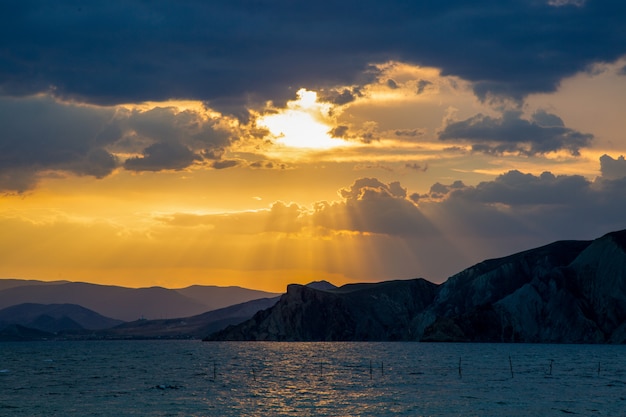 Hermoso colorido amanecer en el mar con espectaculares nubes y sol brillando