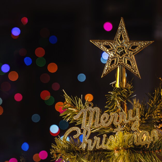 Hermoso concepto de decoración navideña, chuchería colgando del árbol de Navidad con punto de luz brillante, fondo negro oscuro borroso, detalle macro, de cerca.