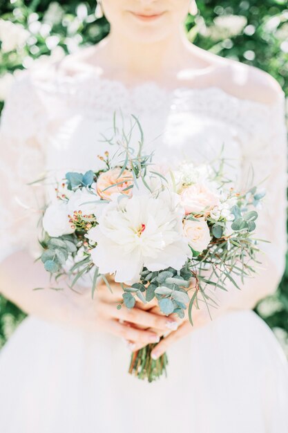 Hermoso y delicado ramo de novia en manos de la novia