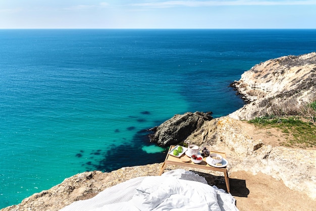 Hermoso desayuno festivo con vista al mar en el precipicio Viajes y concepto de estilo de vida saludable