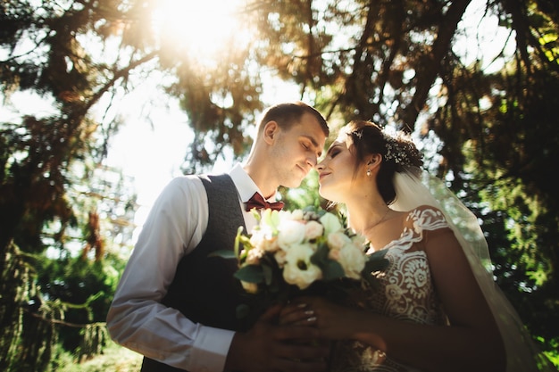 Foto hermoso día soleado. novios posando en el fondo de la naturaleza